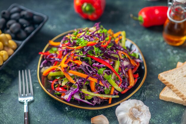 Vista frontal sabrosa ensalada de repollo con aceitunas sobre fondo oscuro, dieta de vacaciones, comida saludable, almuerzo, merienda, pan