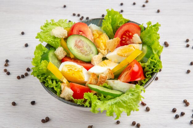 Vista frontal sabrosa ensalada de verduras con huevos sobre fondo claro comida ensalada dieta vida saludable comida madura almuerzo desayuno