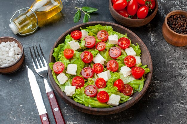 Vista frontal sabrosa ensalada de verduras con tomates con queso en rodajas y condimentos sobre fondo oscuro almuerzo dieta saludable comida comida color