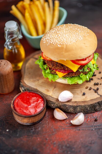 Vista frontal sabrosa hamburguesa de carne con papas fritas en piso oscuro