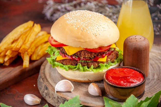 Vista frontal sabrosa hamburguesa de carne con papas fritas sobre fondo oscuro