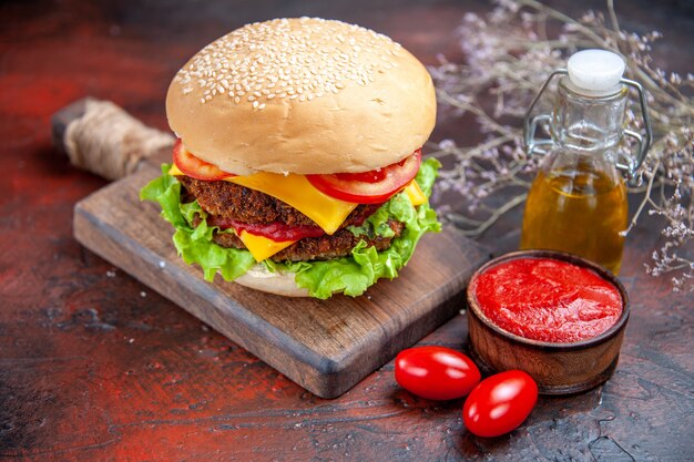 Vista frontal sabrosa hamburguesa de carne con queso sobre un fondo oscuro