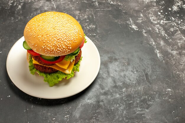 Vista frontal sabrosa hamburguesa de carne con verduras en pan de comida rápida sándwich de superficie gris