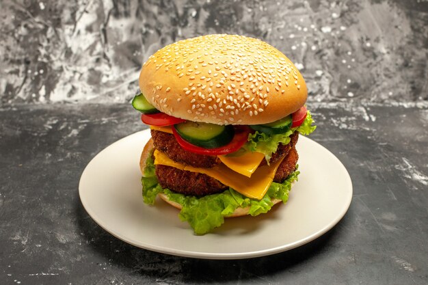 Vista frontal sabrosa hamburguesa de carne con verduras en pan de comida rápida sándwich de superficie oscura