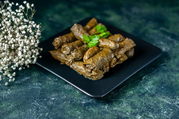 Vista frontal de la sabrosa hoja dolma dentro de la placa sobre fondo oscuro aceite de calorías cena comida restaurante comida ensalada carne