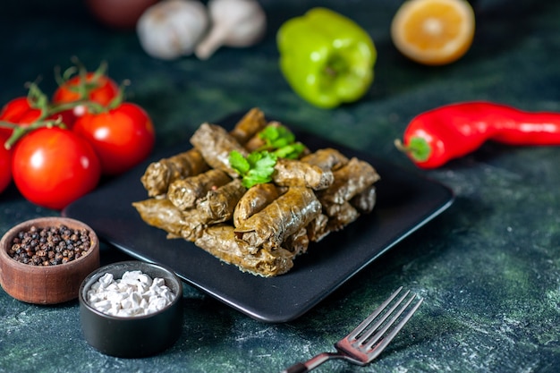 Vista frontal de la sabrosa hoja dolma con tomates en el escritorio oscuro aceite de calorías cena comida ensalada plato carne restaurante comida