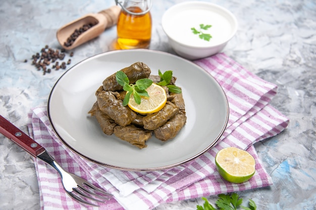 Vista frontal de la sabrosa hoja de dolma con yogur sobre superficie blanca