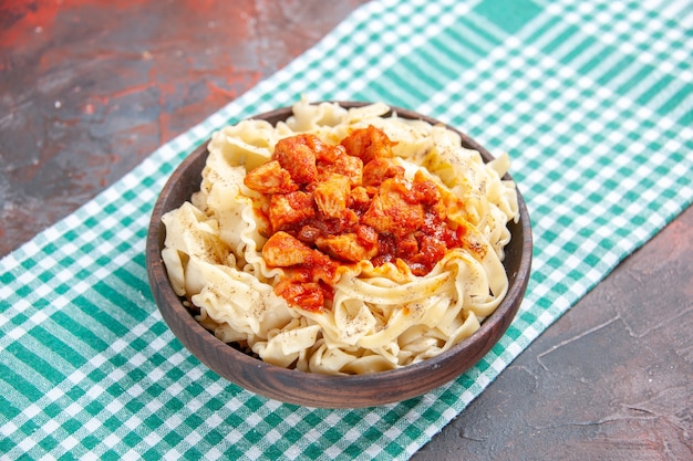 Vista frontal sabrosa masa cocida con pollo y salsa en el plato de comida de escritorio oscuro pasta