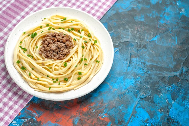 Vista frontal sabrosa pasta italiana con carne molida en plato azul masa de carne comida de color