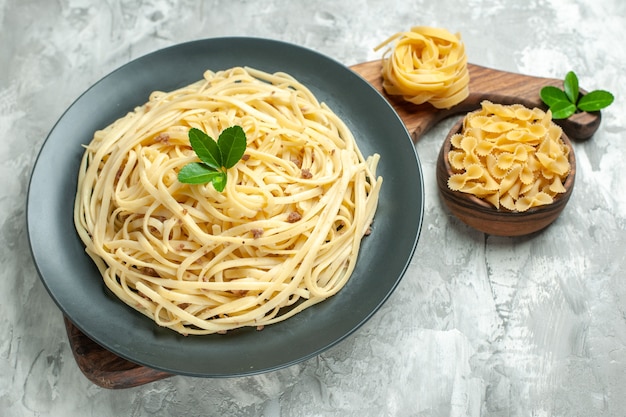 Vista frontal de la sabrosa pasta italiana en comida de color claro foto masa de comida