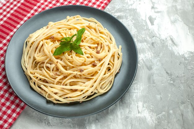 Vista frontal sabrosa pasta italiana en plato de masa de comida de fotografía blanca