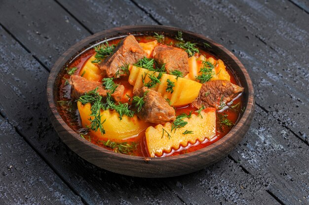 Vista frontal sabrosa sopa de carne con patatas y verduras en la salsa de plato de carne de comida de escritorio oscuro