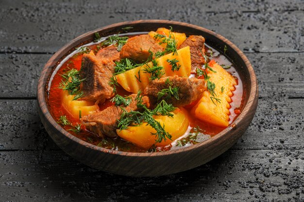 Vista frontal sabrosa sopa de carne con patatas y verduras en la salsa de plato de carne de comida de escritorio oscuro