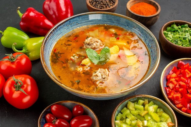 Vista frontal sabrosa sopa de carne con verduras frescas sobre un fondo oscuro