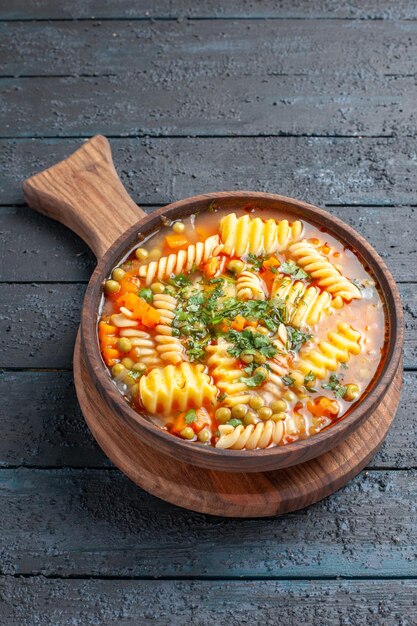 Vista frontal sabrosa sopa de pasta de pasta italiana en espiral con verduras en el escritorio azul oscuro plato de cocina de color sopa de pasta italiana