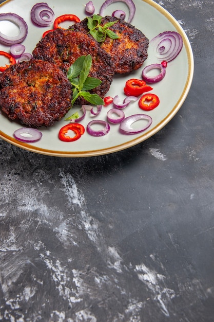 Foto gratuita vista frontal sabrosas chuletas de carne con aros de cebolla