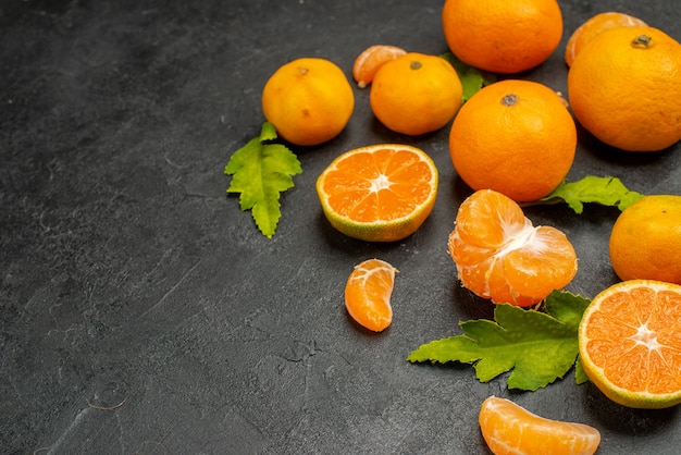 Vista frontal sabrosas mandarinas jugosas sobre fondo oscuro color naranja frutas exóticas cítricos foto agria