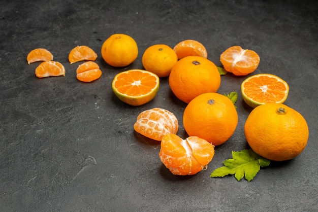 Vista frontal sabrosas mandarinas jugosas sobre fondo oscuro exóticos cítricos fotografía en color naranja fruta agria
