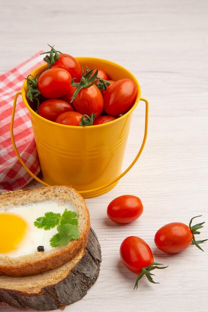 Vista frontal sabrosas tostadas de huevo con tomates sobre fondo blanco desayuno ensalada comida foto comida de la mañana color almuerzo