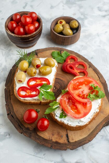 Vista frontal sabrosas tostadas con tomates y aceitunas en tablero de madera fondo blanco almuerzo comida pan comida horizontal cena bocadillo hamburguesa
