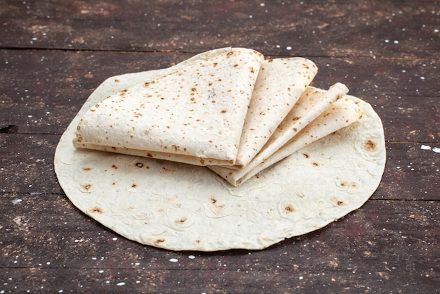 Vista frontal sabroso pan de masa lavash como en un escritorio de madera breafd doough comida comida