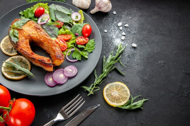Vista frontal sabroso pescado cocido con verduras frescas sobre fondo oscuro foto comida de mariscos plato color carne