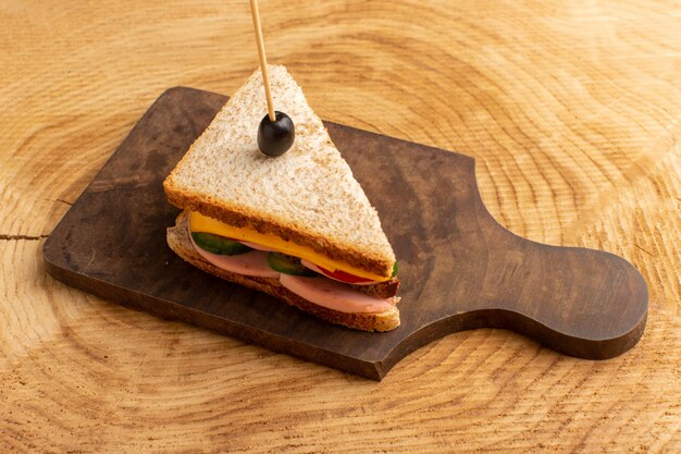 Vista frontal sabroso sándwich con jamón de oliva tomates verduras en madera