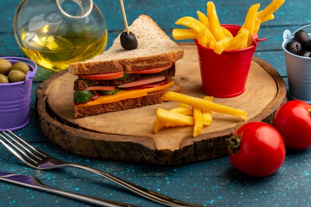 Vista frontal sabroso sándwich de pan tostado con jamón de queso dentro con aceitunas papas fritas aceite de tomates en azul