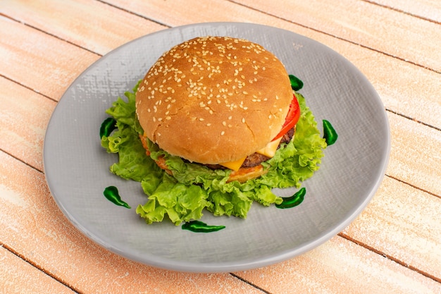 Vista frontal sabroso sándwich de pollo con ensalada verde y verduras dentro de la placa en el piso de crema de madera hamburguesa hamburguesa de pan de comida rápida