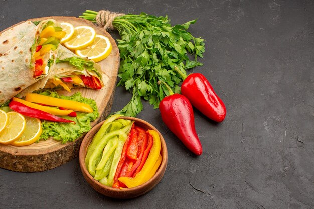 Vista frontal sabroso sándwich de pollo en rodajas de shaurma con limón y verduras en el espacio oscuro