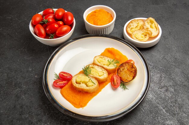 Vista frontal sabrosos pasteles de patata con calabaza y tomates frescos sobre fondo gris hornear el plato de color del horno de la cena madura