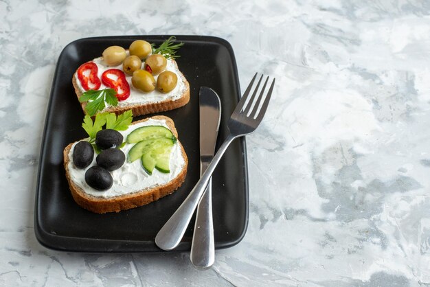 Vista frontal sabrosos sándwiches con pepinos y aceitunas sobre fondo blanco almuerzo hamburguesa pan horizontal comida saludable comida tostada