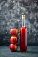 Foto gratuita vista frontal de la salsa de manzana de color rojo con manzanas frescas en salsa de bebida de fruta de color gris comida de ketchup vino de árbol