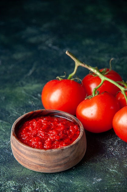 Foto gratuita vista frontal de la salsa de tomate con tomates rojos frescos en la superficie de color azul oscuro tomate rojo condimento sal pimienta