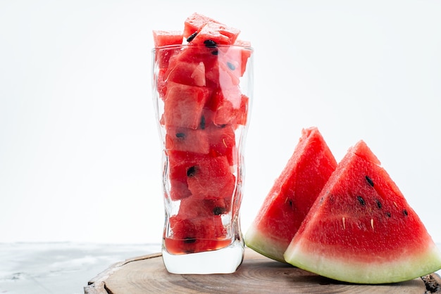 Una vista frontal de la sandía fresca en rodajas jugosa y dulce dentro de un vaso largo en blanco, jugo de fruta de color de verano