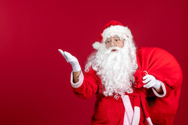 Vista frontal de santa claus con una bolsa roja llena de regalos en las vacaciones de navidad de año nuevo de emoción roja