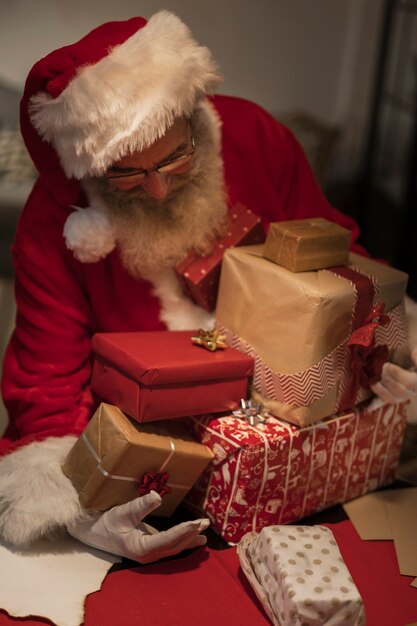 Vista frontal de santa claus con cajas de regalo