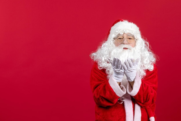 Foto gratuita vista frontal de santa claus con el clásico oso blanco y ropa roja enviando besos en las vacaciones de año nuevo de navidad roja