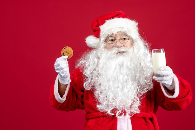 Foto gratuita vista frontal de santa claus comiendo galletas y bebiendo leche