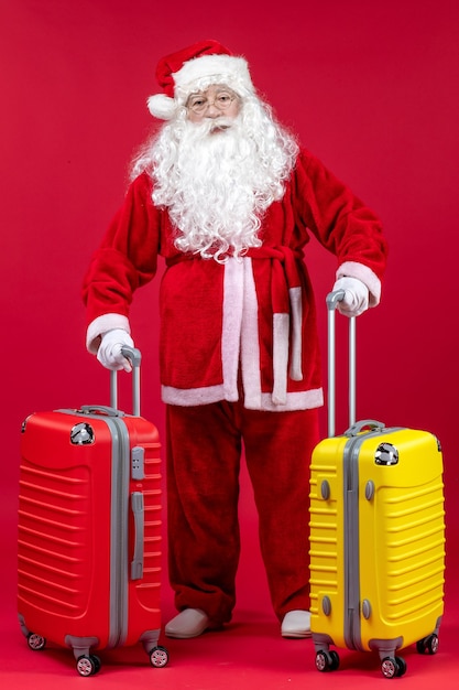 Vista frontal de santa claus con dos bolsas preparándose para el viaje