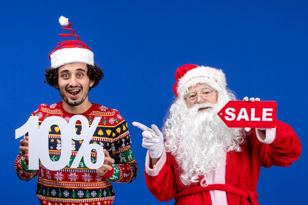 Vista frontal de santa claus con escritura de explotación y venta de varones jóvenes en color azul nieve año nuevo vacaciones de navidad