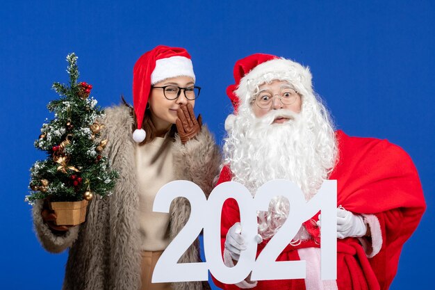 Vista frontal de santa claus con escritura femenina y arbolito de navidad en color azul año nuevo