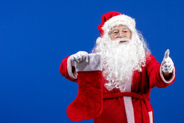 Vista frontal de santa claus con gran calcetín de navidad en colores azules nieve de navidad