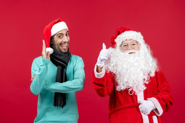 Vista frontal de santa claus con hombre parado en rojo navidad vacaciones presente emociones humor