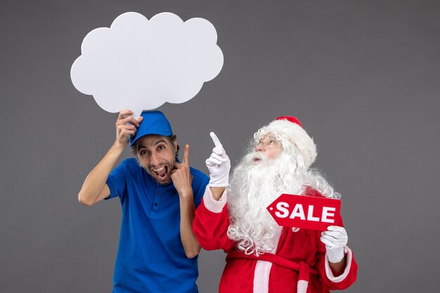 Vista frontal de santa claus con mensajero masculino con cartel de nube blanca y venta en pared gris