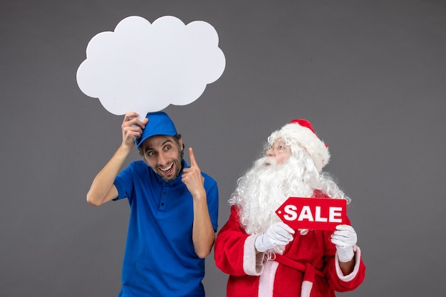 Vista frontal de santa claus con mensajero masculino con cartel de nube blanca y venta en pared gris