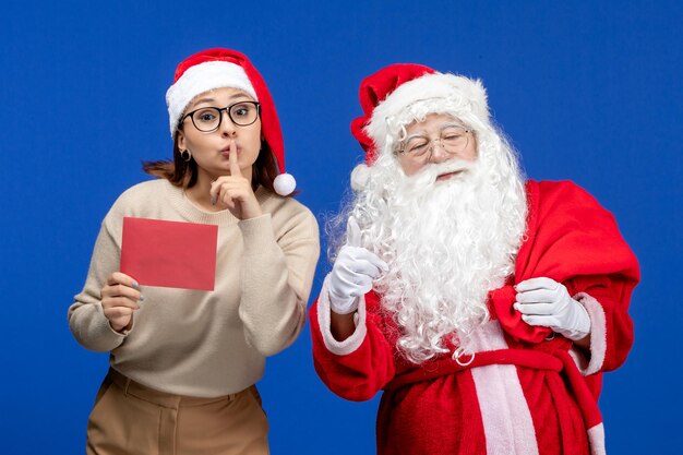 Vista frontal de santa claus y mujer joven con letra en color azul vacaciones emoción navidad año nuevo color