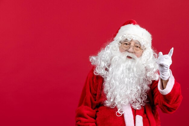 Vista frontal de santa claus con oso blanco clásico y ropa roja en rojo navidad año nuevo