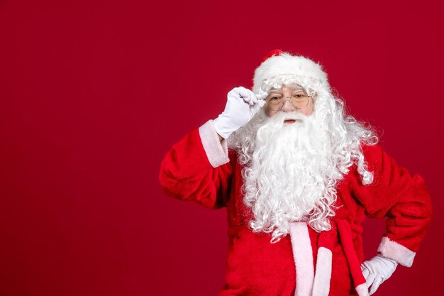 Vista frontal de santa claus con oso blanco clásico y ropa roja en rojo