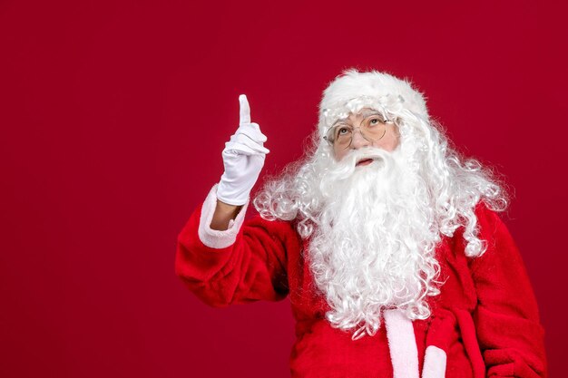 Vista frontal de santa claus con oso blanco clásico y ropa roja en vacaciones rojas de navidad